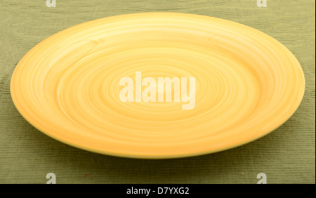 empty yellow plate on a green textured background Stock Photo