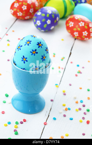 Painted easter eggs on white table with sugar sprinkles Stock Photo