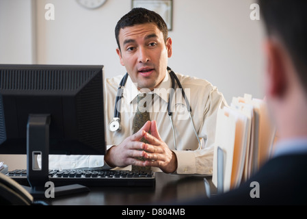 Doctor talking to clients in office Stock Photo