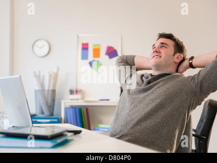 Businessman relaxing at desk in office Stock Photo