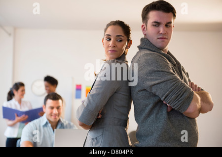 Business people standing back to back in office Stock Photo