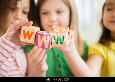 Girls holding colorful 'w' blocks Stock Photo