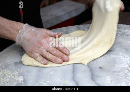 man making pizza stretching base dough deliberate motion blur Stock Photo