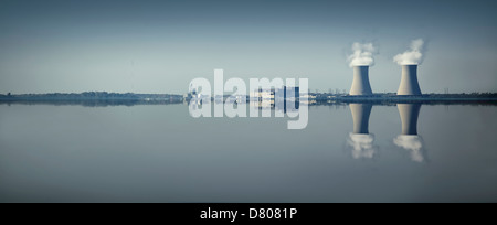 Smoke stacks and factory reflected in still lake Stock Photo