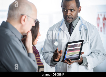 Doctor showing tablet computer to patients Stock Photo