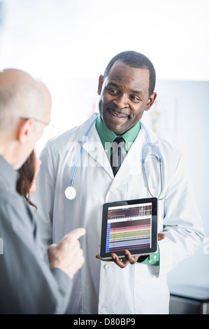 Doctor showing tablet computer to patients Stock Photo