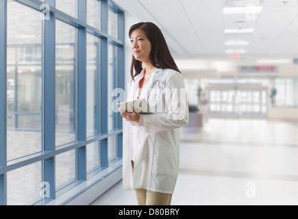 Asian doctor walking in hospital Stock Photo