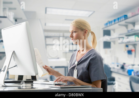Caucasian nurse working at computer in hospital Stock Photo