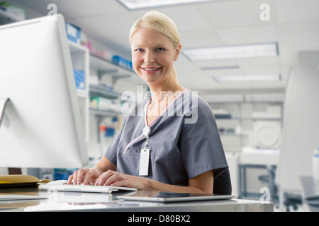 Caucasian nurse working at computer in hospital Stock Photo