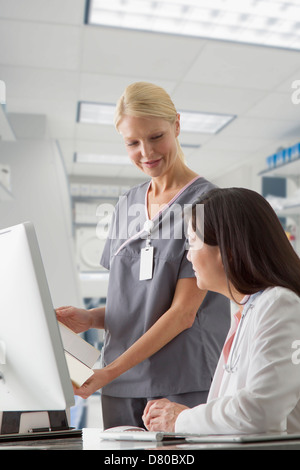 Doctor and nurse working at computer in hospital Stock Photo