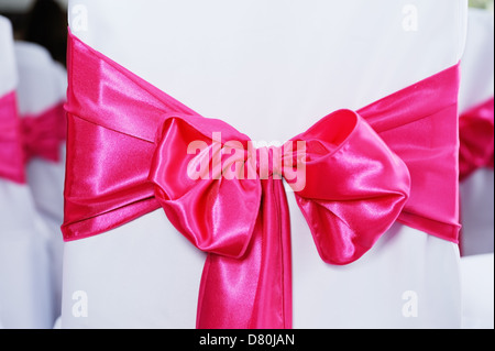 Closeup of red bow on chair cover at wedding reception Stock Photo