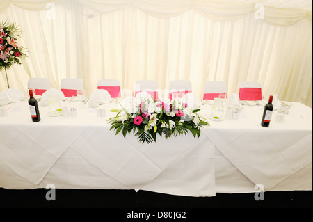 Wedding reception table decorated with red flowers Stock Photo