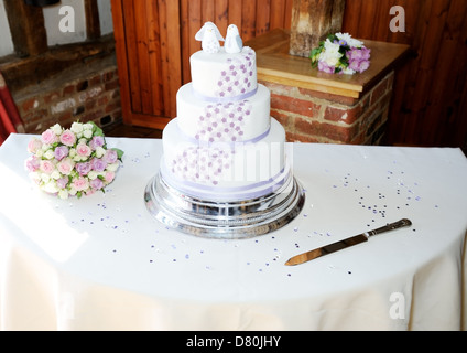 Wedding cake and brides bouquet with decoration and knife Stock Photo