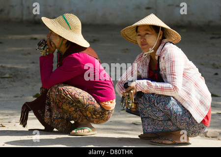 Two girls squatting in the road at Mingun, Myanmar Stock Photo