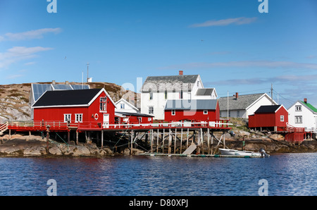 Traditional Norwegian village with red and white wooden houses on rocky coast Stock Photo