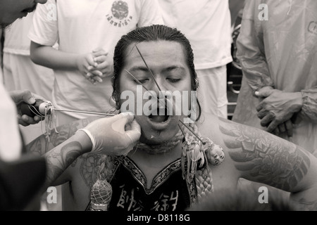 PHUKET, THAILAND OCTOBER 3 2011: A spirit medium has his face pierced at the annual Phuket Vegetarian Festival. Stock Photo