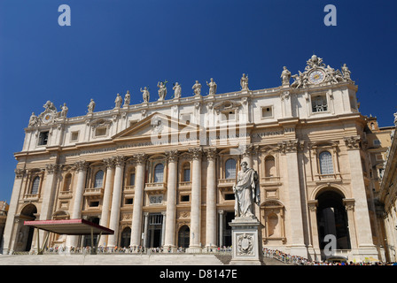 Statue of St Paul with crowds at Saint Peters Papal Basilica in Rome Italy with blue sky Stock Photo