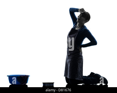 one  woman maid cleaning backache washing floor in silhouette studio isolated on white background Stock Photo