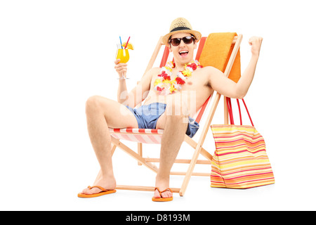 Happy young man enjoying a cocktail and sitting on a beach chair, isolated on white background Stock Photo