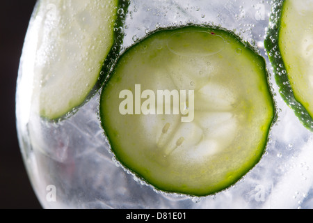 Gin tonic cocktail with cucumber and ice macro closeup on black Stock Photo