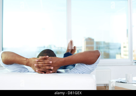 Image of young African man lying on sofa and having rest Stock Photo