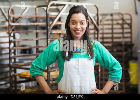 Mixed race woman working in bakery kitchen Stock Photo