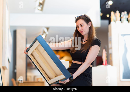 Caucasian woman examining painting in art gallery Stock Photo