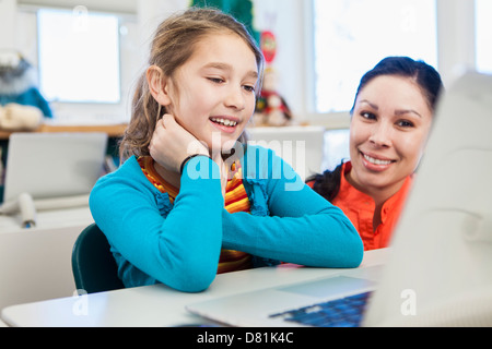 Teacher and student using laptop in library Stock Photo