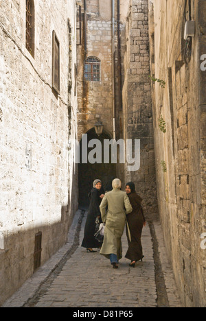 Aleppo, Syria. Women walking down a narrow old cobbled street in the old city centre, a UNESCO World Heritage Site. Stock Photo