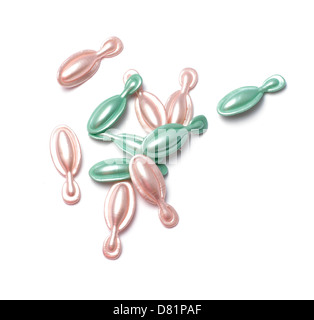 pink and green capsules cut out onto a white background Stock Photo