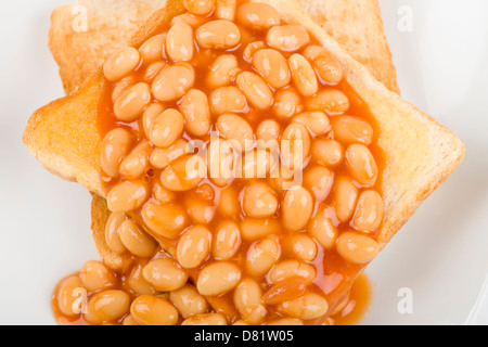 Beans on Toast - Slices of toasted white bread, buttered and topped with baked beans. Simple British breakfast meal. Stock Photo