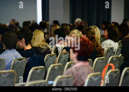 Young female turning to her friend for an opinion during a lecture Stock Photo