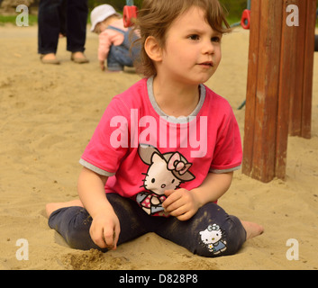 Little girl playing in sand at playground Stock Photo