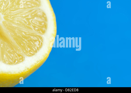 Cut lemon on blue background. Differential focus. Stock Photo