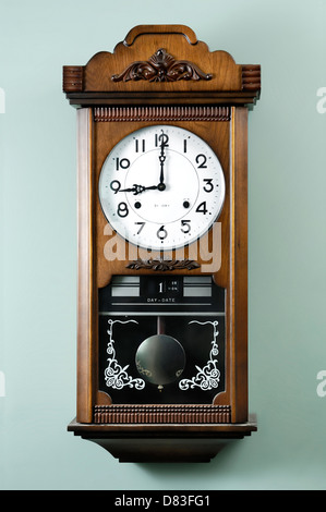 Antique wall clock with a pendulum showing nine Stock Photo