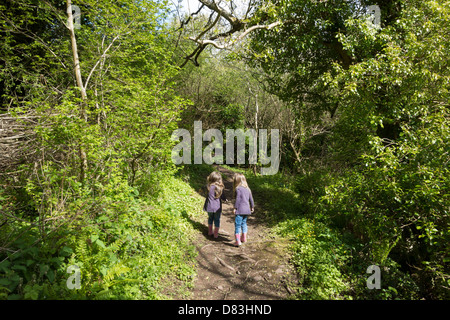 2 girls walk together along a woodland nature trail path. Stock Photo