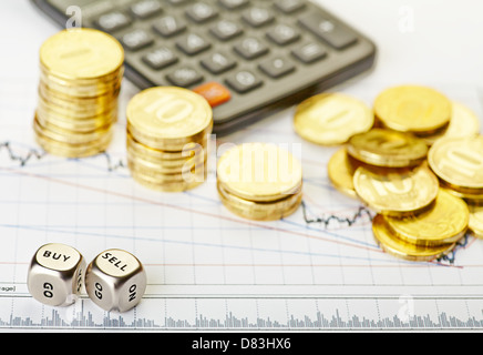 Downtrend stacks of golden coins, dices cubes with the words SELL BUY, calculator on the financial stock charts. Selective focus Stock Photo