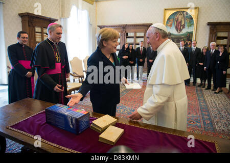 HANDOUT - Bundeskanzlerin Angela Merkel und Papst Franziskus aufgenommen nach ihrem Treffen am 18.05.2013 im Vatikan bei der Übergabe der Gastgeschenke: Bücher von Hölderlin und einer Gesamtausgabe von Wilhelm Furtwängler. Foto: Pool / Bundesregierung / Bergmann Stock Photo