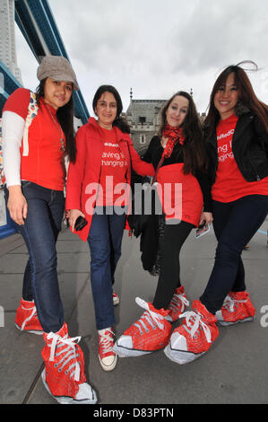 Tower Bridge, London, UK. 18th May 2013. Red Shoe Walk in aid of Red Cross Week, a charity walk through central London, with the walkers wearing red shoes or slip over red covers. Credit:  Matthew Chattle / Alamy Live News Stock Photo