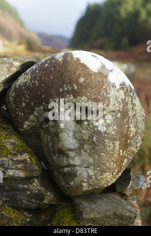 Stone sculpted human faces embedded in a dry stone dyke by Matt Baker, Galloway Forest Park, Dumfries & Galloway, Scotland Stock Photo