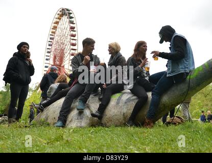 Berlin, Germany. 18th May 2013. Visitors sit on a statue of a dinosaur at the former Spreepark in Berlin, Germany, 18 May 2013. The London Indie band The XX invited befriended musicians to a concert at the deserted Spreepark area. Photo: BRITTA PEDERSEN/dpa/Alamy Live News Stock Photo