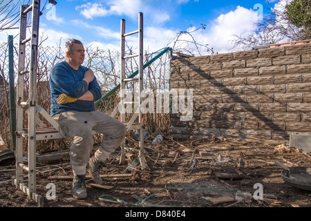 A builder taking a break on some scaffolding Stock Photo