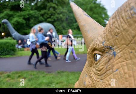 Berlin, Germany. 18th May 2013. Visitors walk past dinosaur figures in the former Spreepark in Berlin, Germany, 18 May 2013.  The London Indie band The XX invited musician friends to a concert at the deserted Spreepark area. Photo: BRITTA PEDERSEN/dpa/Alamy Live News Stock Photo