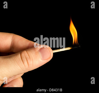 Hand holding burning match stick. Black isolated Stock Photo
