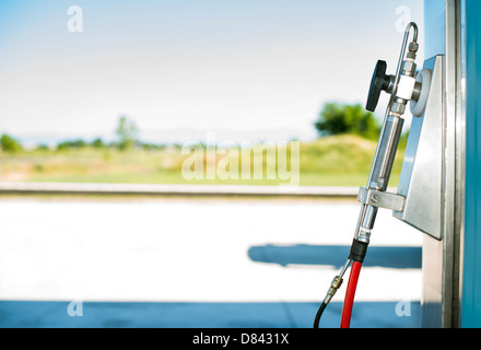 Device for charging gas car on gas station. Stock Photo