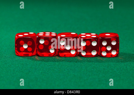 Red dice on green background, closeup Stock Photo