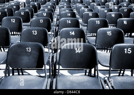 Empty symmetrical rows of plastic stadium seats Stock Photo