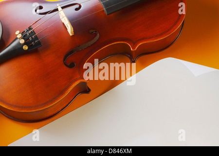 violin and bow with white note paper on yellow background Stock Photo