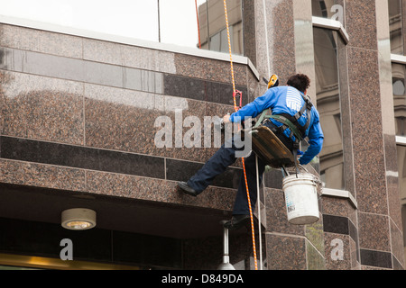 High rise building window washer repelling from job - USA Stock Photo
