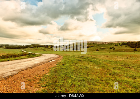 asphalt road and cloudy sky on a mountain plateau. Stock Photo